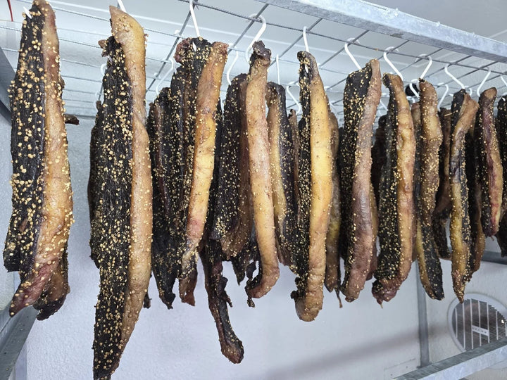’n Ry gekruide biltong aan ’n staalrak.
