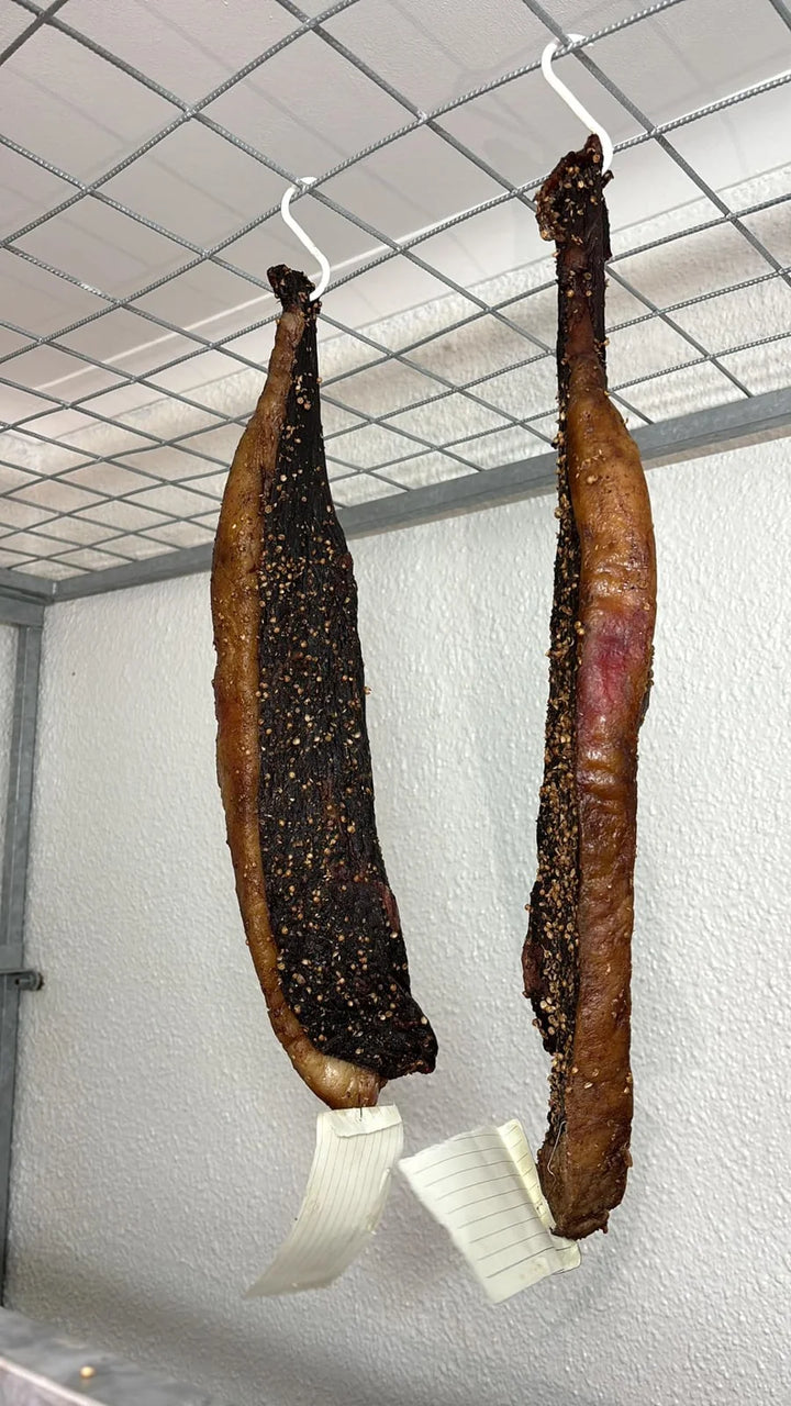 Twee lang stukke biltong aan hake.