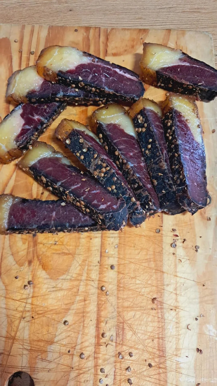 Gesnyde biltong op ’n houtplank.