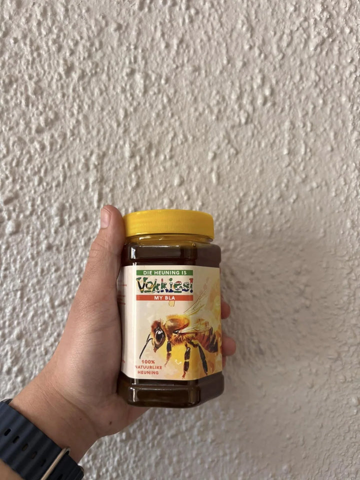 ’n Hand hou ’n Vokkies-produk met ’n geel deksel vas.