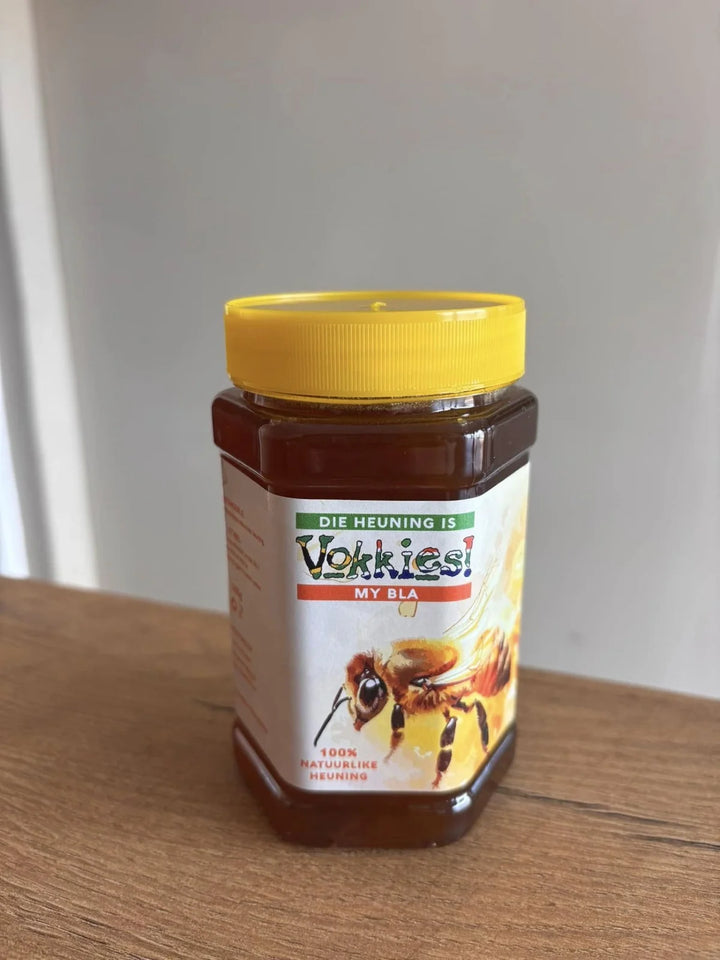 ’n Vokkies-potjie met ’n geel deksel op ’n houtoppervlak.