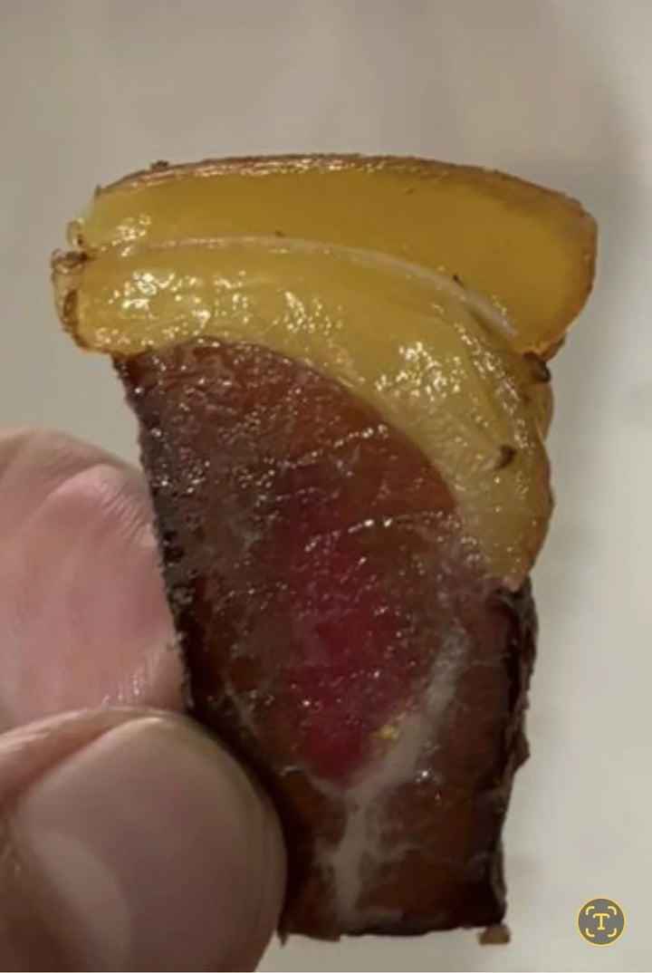 ’n Dun skyf biltong met ’n dik lagie geelvet van naby.